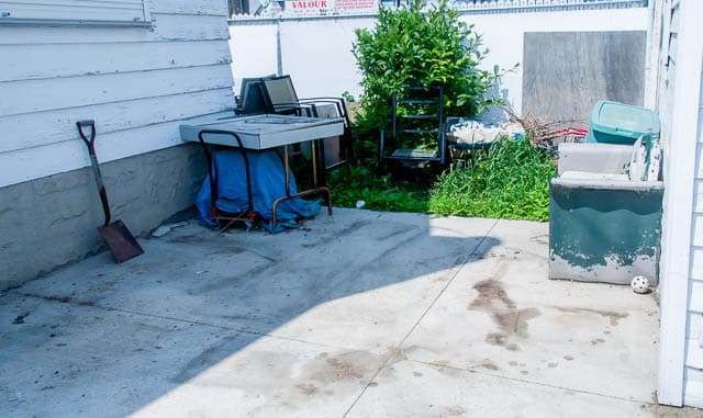 Backyard clutter with old furniture, yard waste, and junk before removal – Mr. Garbage’s junk removal and waste management services in Winnipeg.