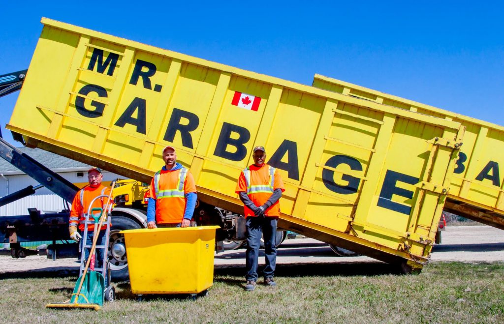 Mr. Garbage waste management team with yellow dumpster rental truck in Winnipeg, Canada.