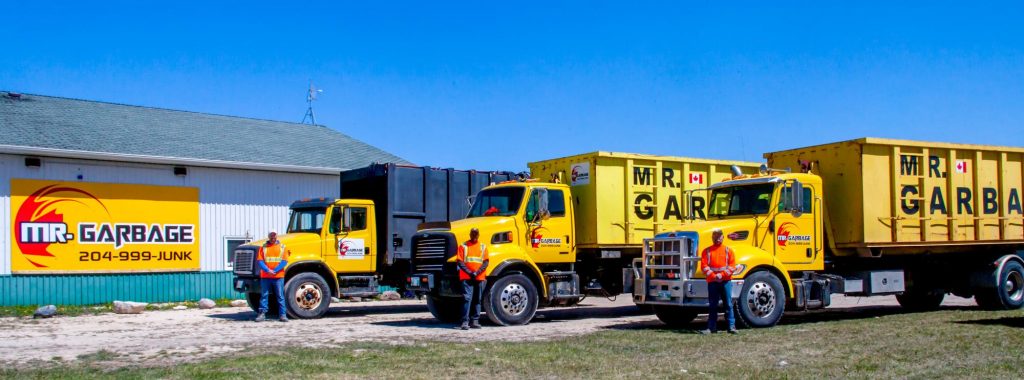 Mr. Garbage waste management trucks lined up outside the company facility in Winnipeg, with staff standing beside bright yellow bin rental vehicles.”