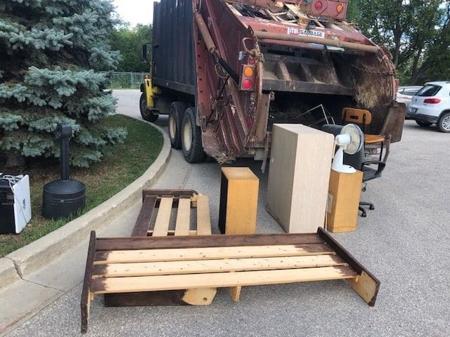 Mr. Garbage junk removal truck picking up old furniture and household waste in Winnipeg.